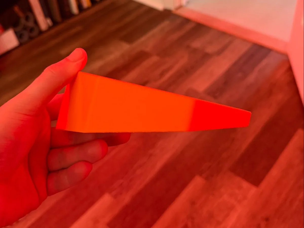 Side profile of the finished orange platform, showing its wedge-shaped tilt.