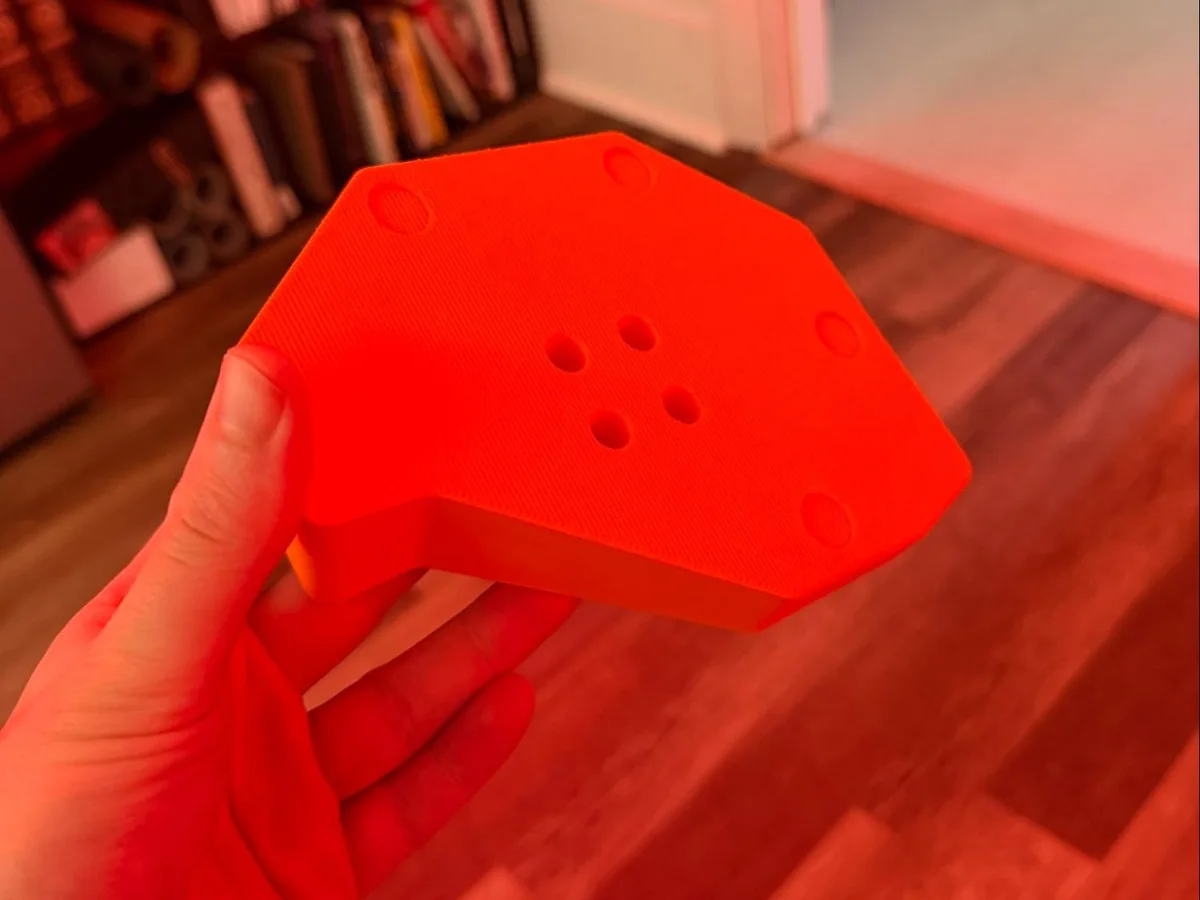 Top view of the finished orange platform, showing mounting holes and recessed features.
